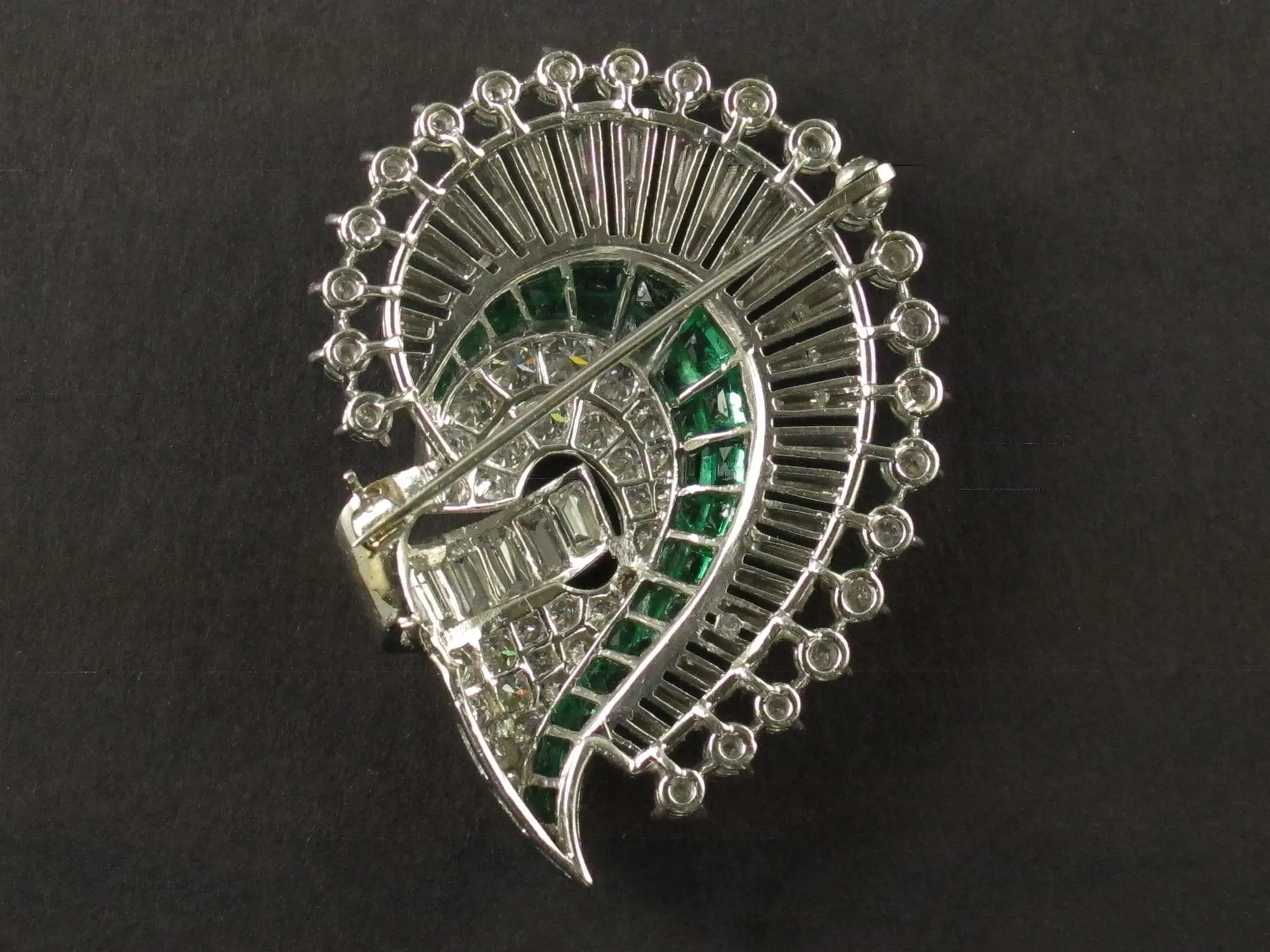 An Art Déco platinum, diamond and emerald brooch. 1925 circa